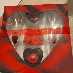 2 Champagne Flutes With Red Hearts and Crooked Stems and Candles and Rose Petals